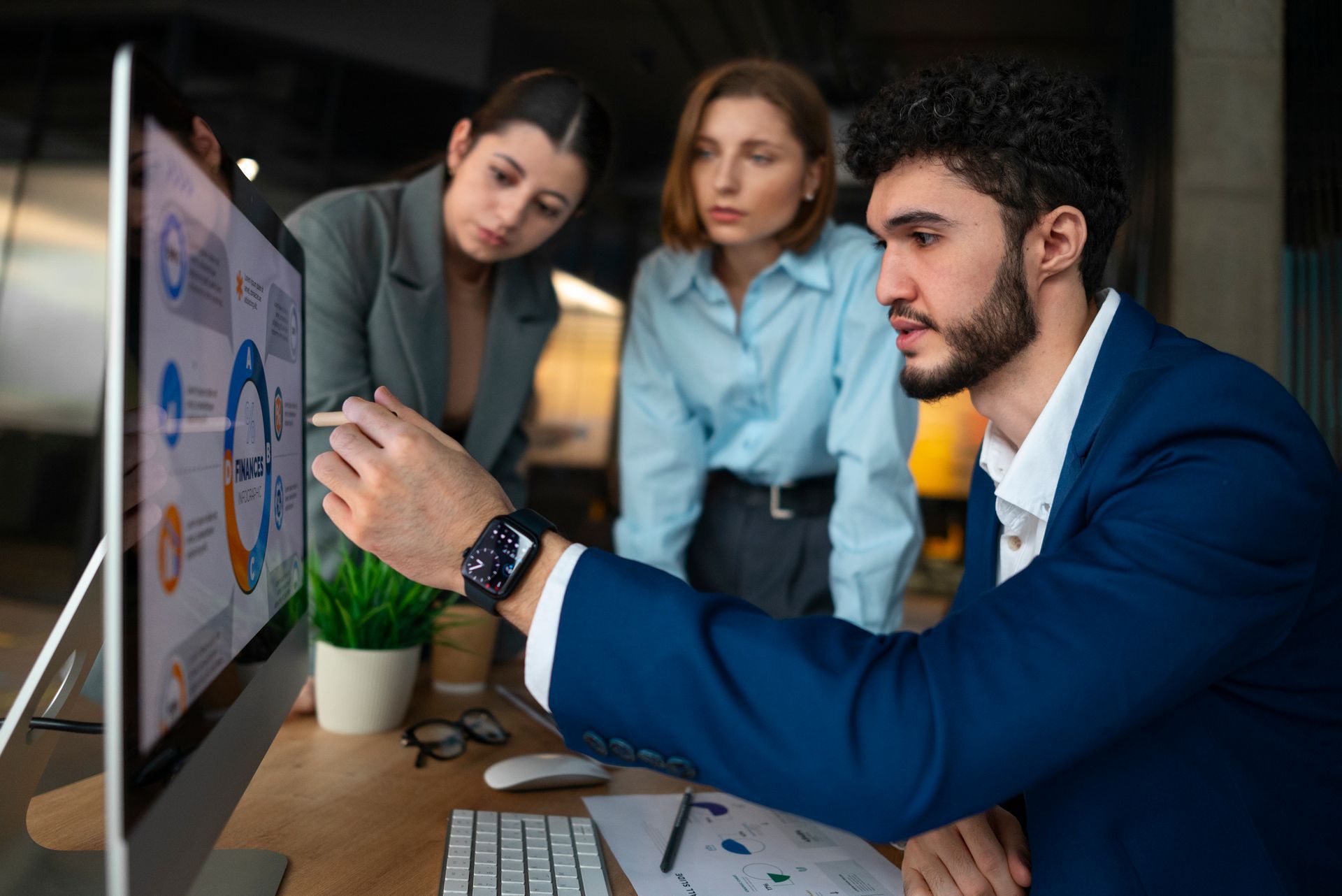 A man and two women are looking at a computer screen.