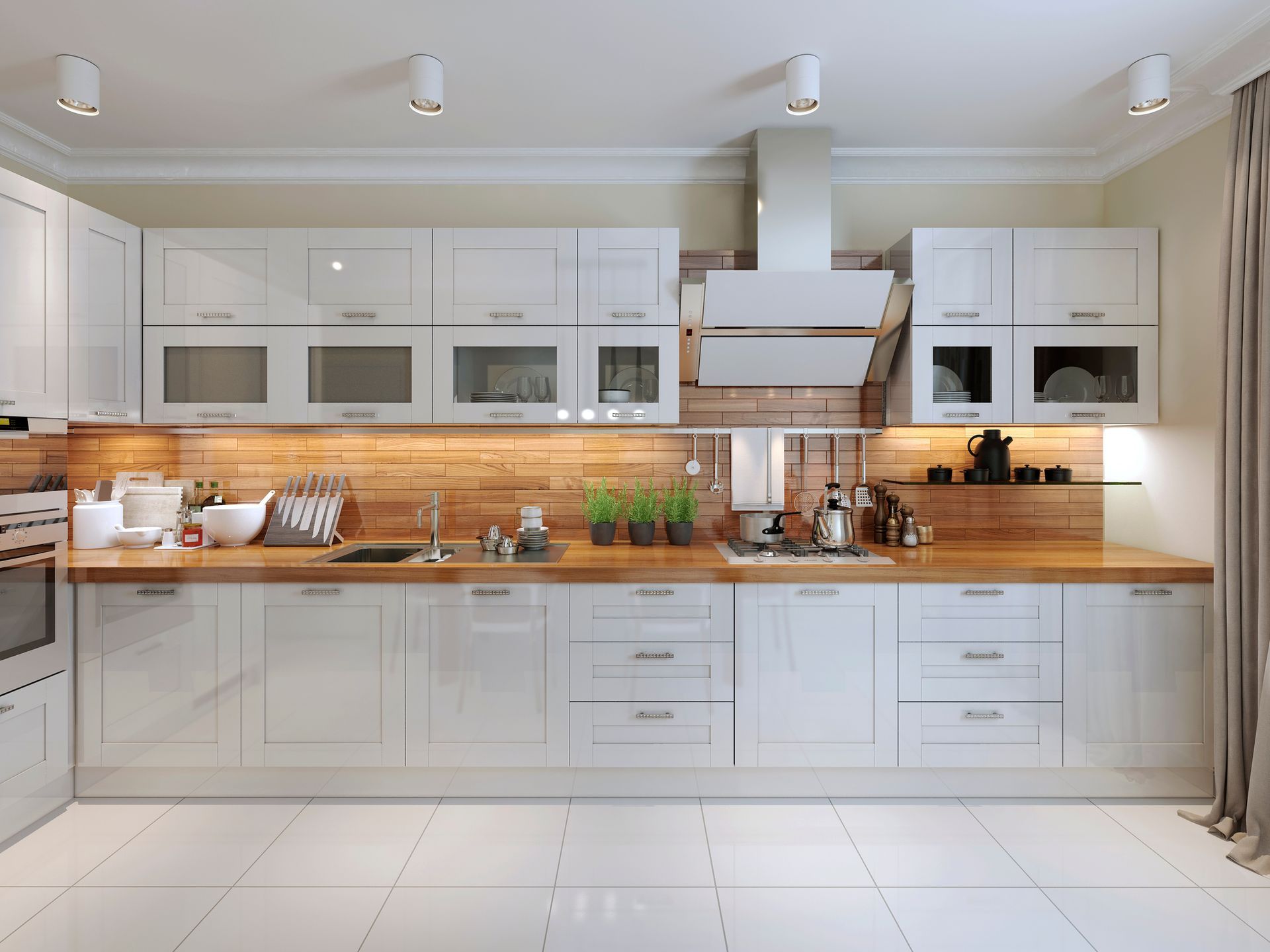 Modern white kitchen with wooden countertops, tile floor, and overhead lighting.