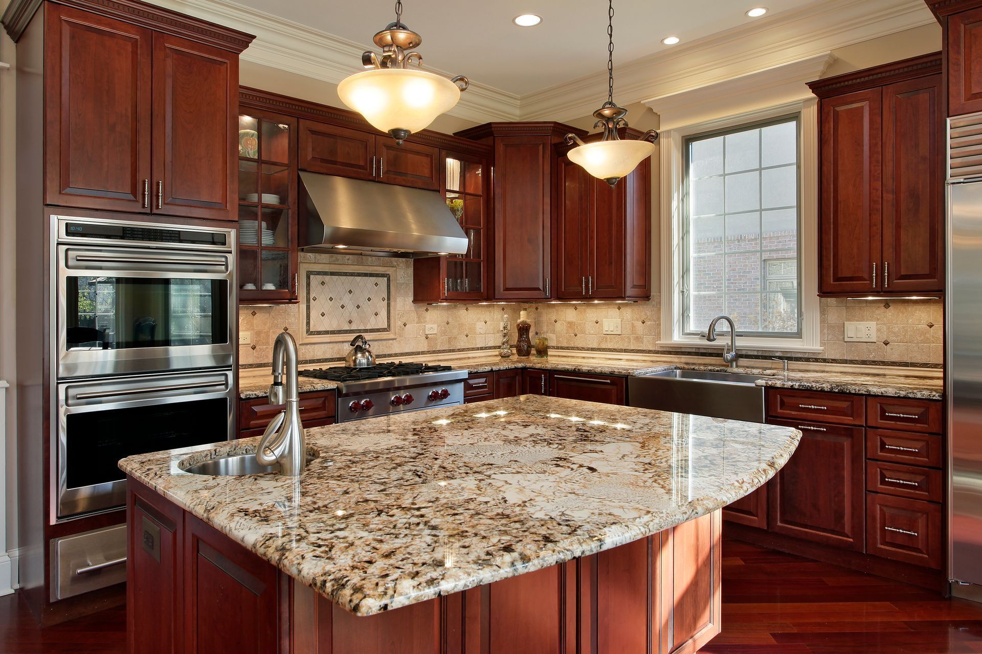 Kitchen with cherry wood cabinets, granite countertops, stainless steel appliances, and island.
