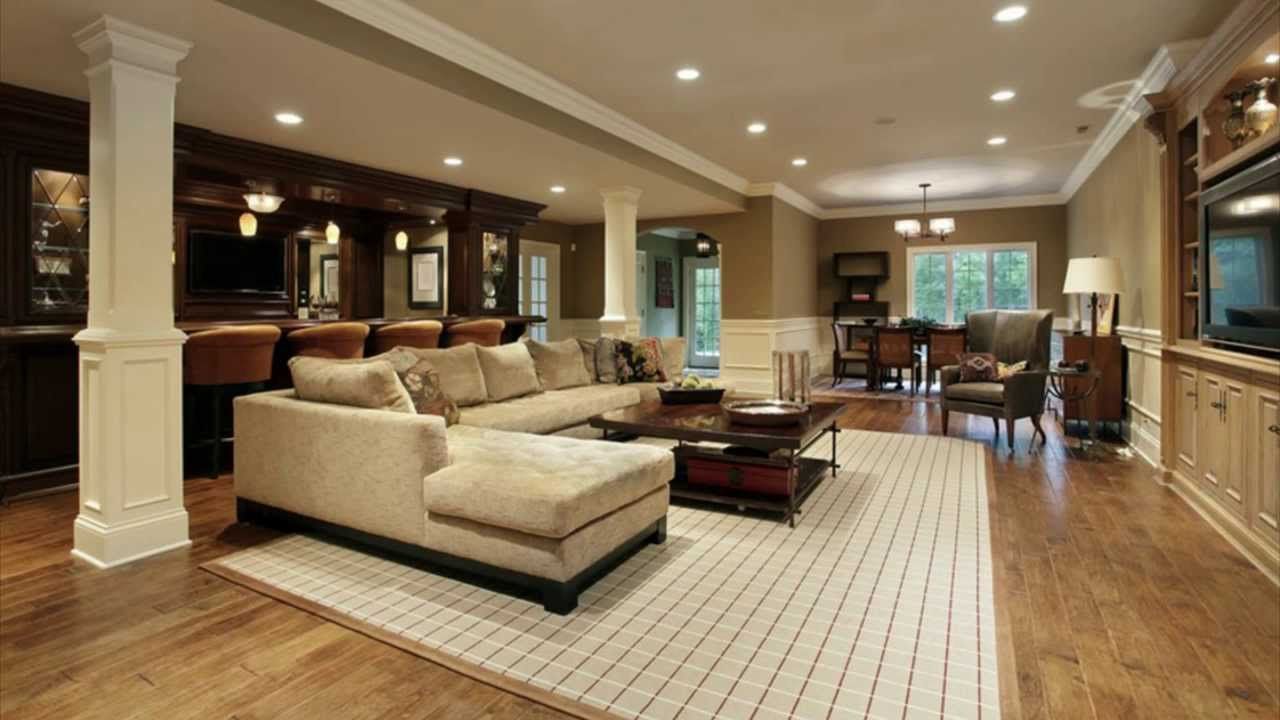 Spacious finished basement with a bar, seating area, and dining room. Light beige walls and dark wood floors.