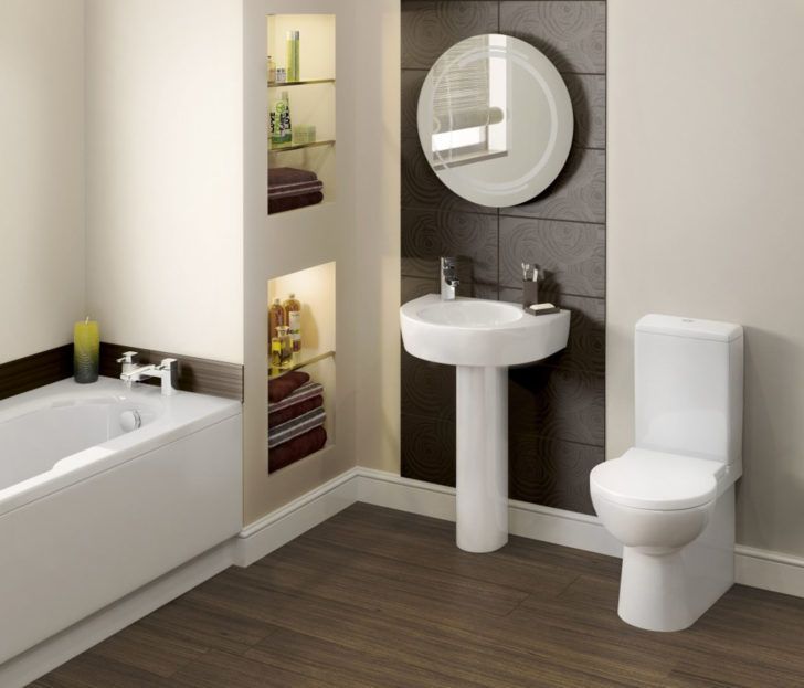 Modern bathroom with a bathtub, toilet, sink, and built-in shelving; earth tones.