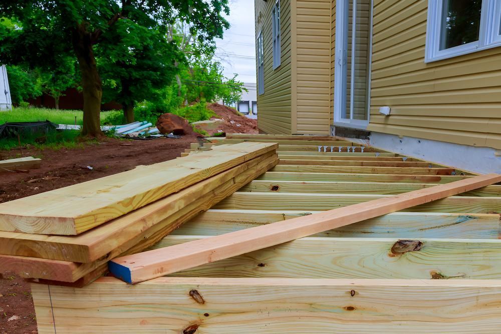 A Wooden Deck is Being Built in Front of a House — Shane Rice Builder & Renovation Specialist In Southside, QLD