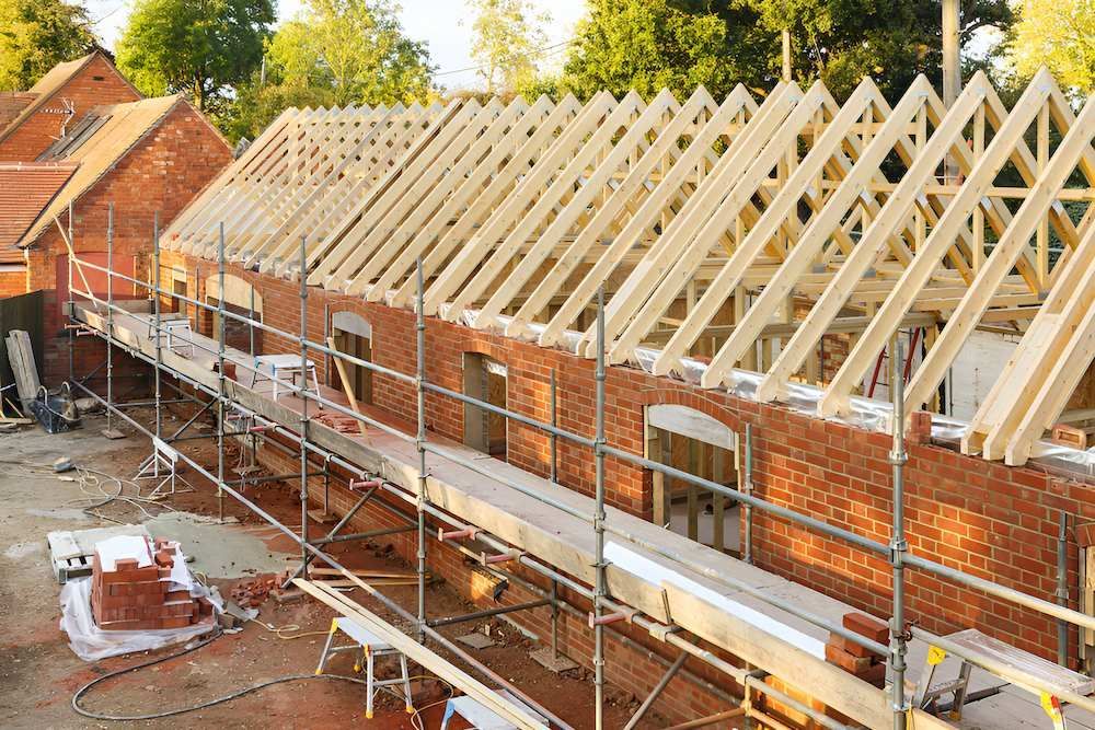 A Brick Building Under Construction With a Wooden Roof — Shane Rice Builder & Renovation Specialist In Southside, QLD