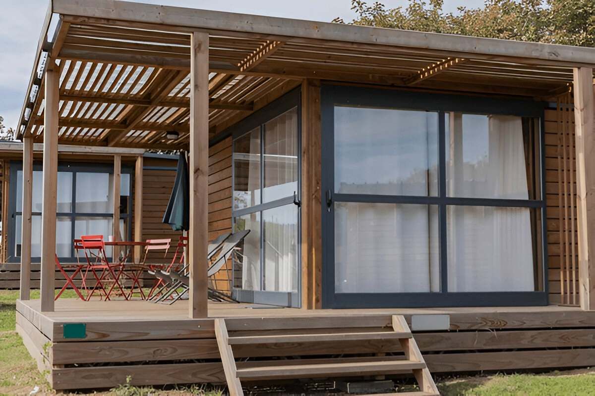 A Small Wooden House With a Porch and Stairs — Shane Rice Builder & Renovation Specialist In Southside, QLD