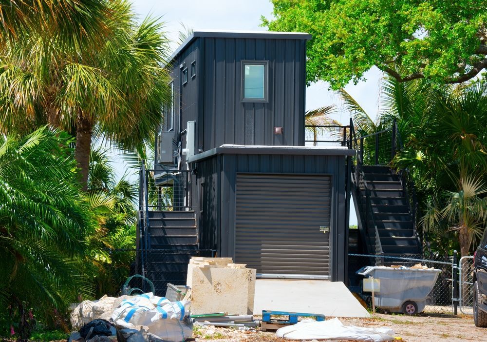 A Black House With a Garage and Stairs is Under Construction — Shane Rice Builder & Renovation Specialist In Southside, QLD