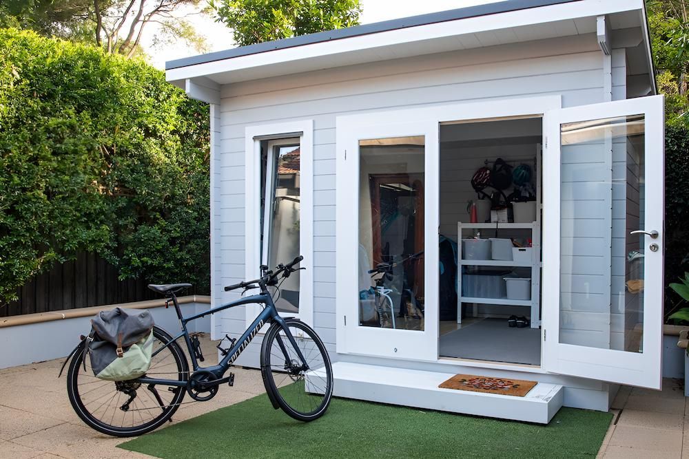 A Bicycle is Parked in Front of a Small White House — Shane Rice Builder & Renovation Specialist In Southside, QLD
