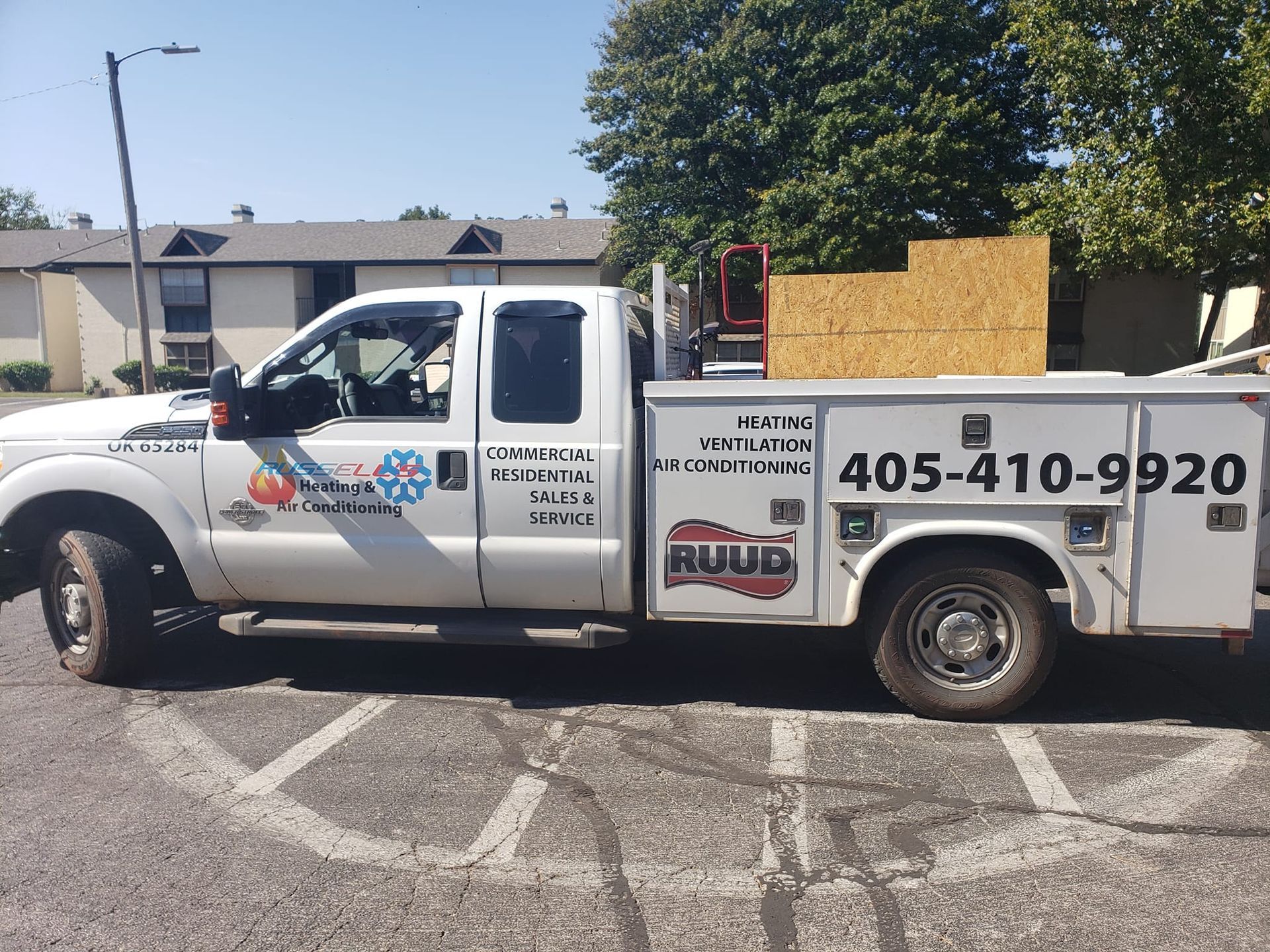 A white utility truck is parked in a parking lot