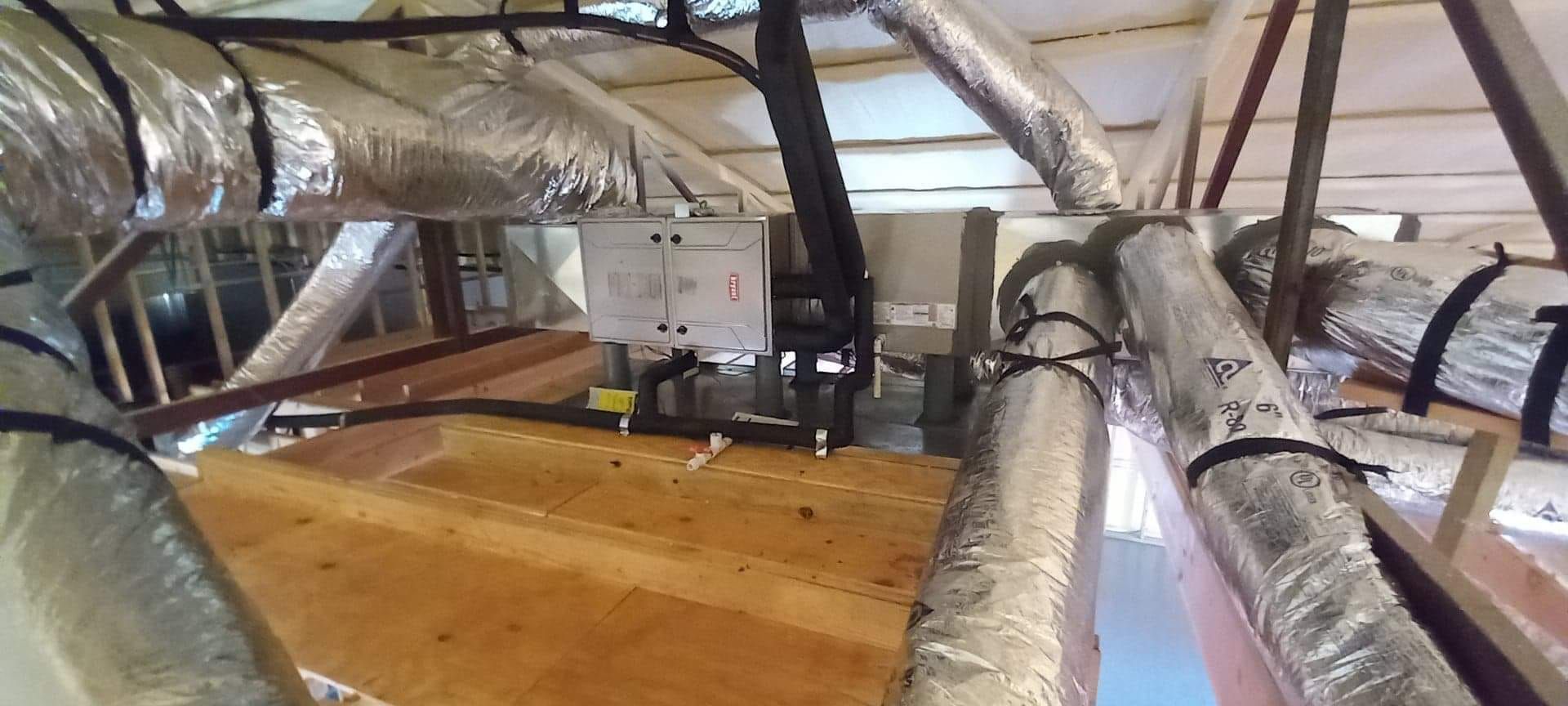 A bunch of pipes are hanging from the ceiling of a building.