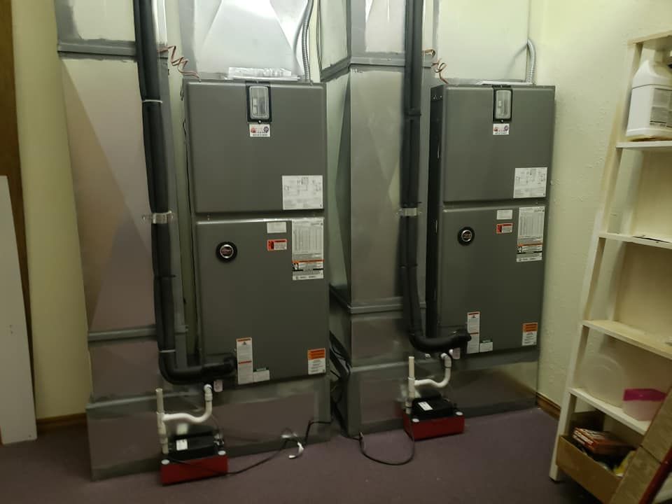 Two air conditioners are stacked on top of each other in a room.
