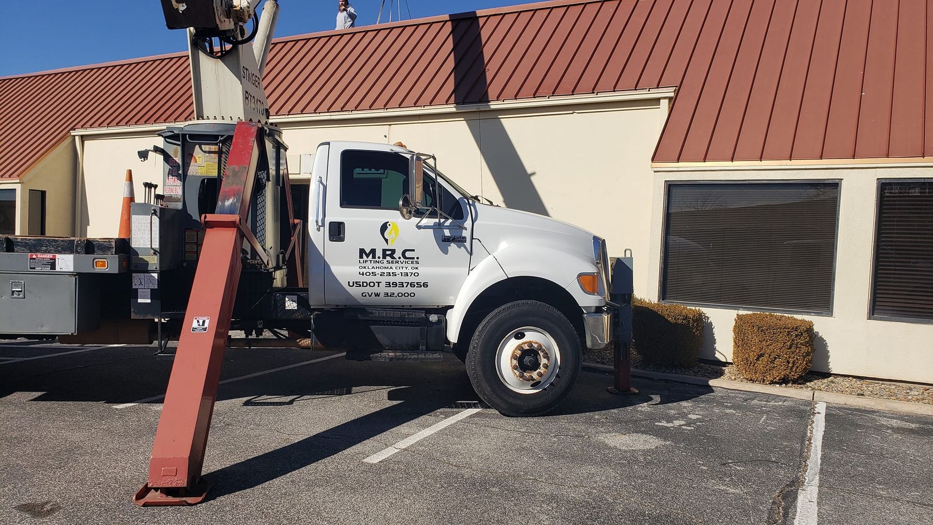 A white truck with hrc written on the side is parked in front of a building
