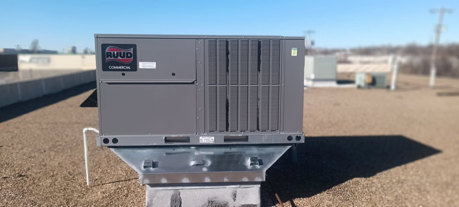 A large air conditioner is sitting on top of a roof.