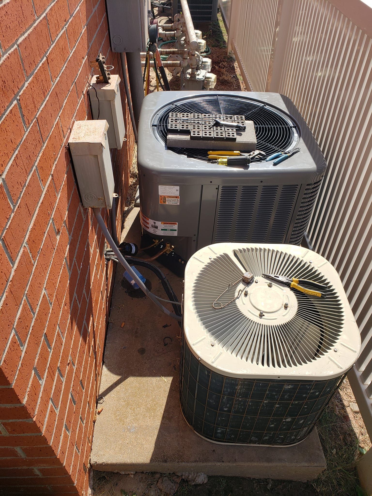A couple of air conditioners are sitting next to each other on the side of a building.