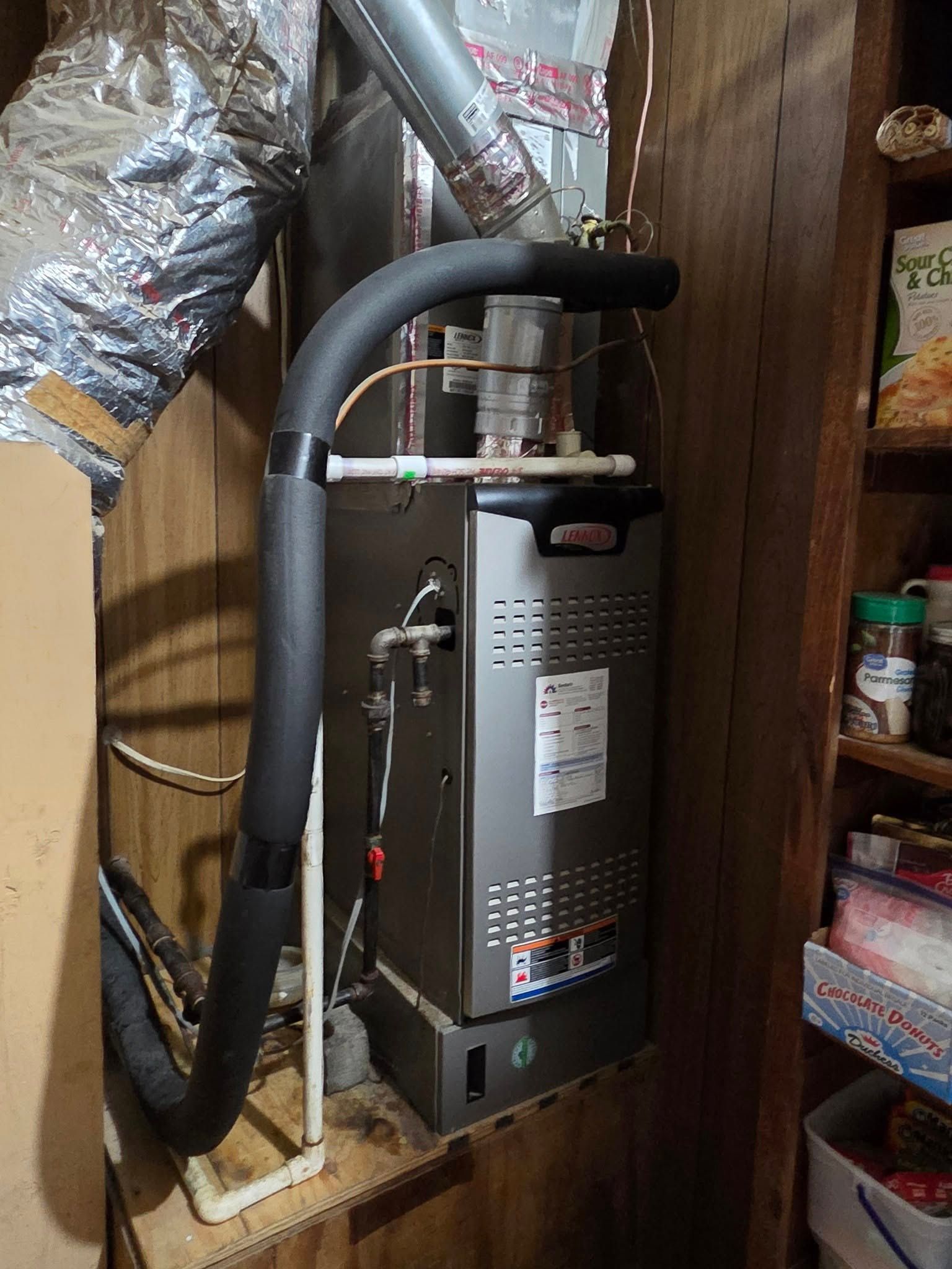 A gas heater is sitting on top of a wooden shelf in a room.