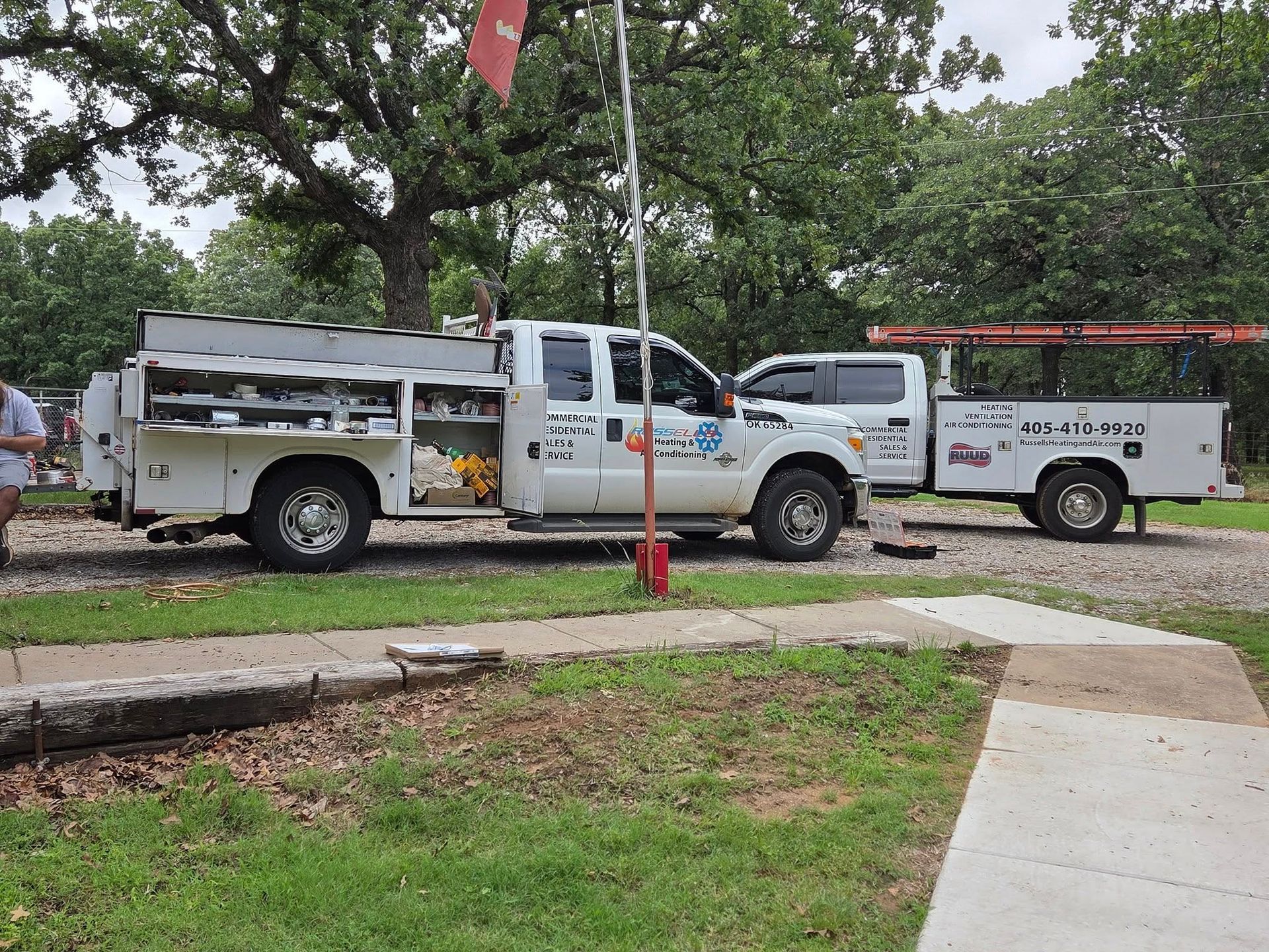 Two utility trucks are parked next to each other on the side of the road.