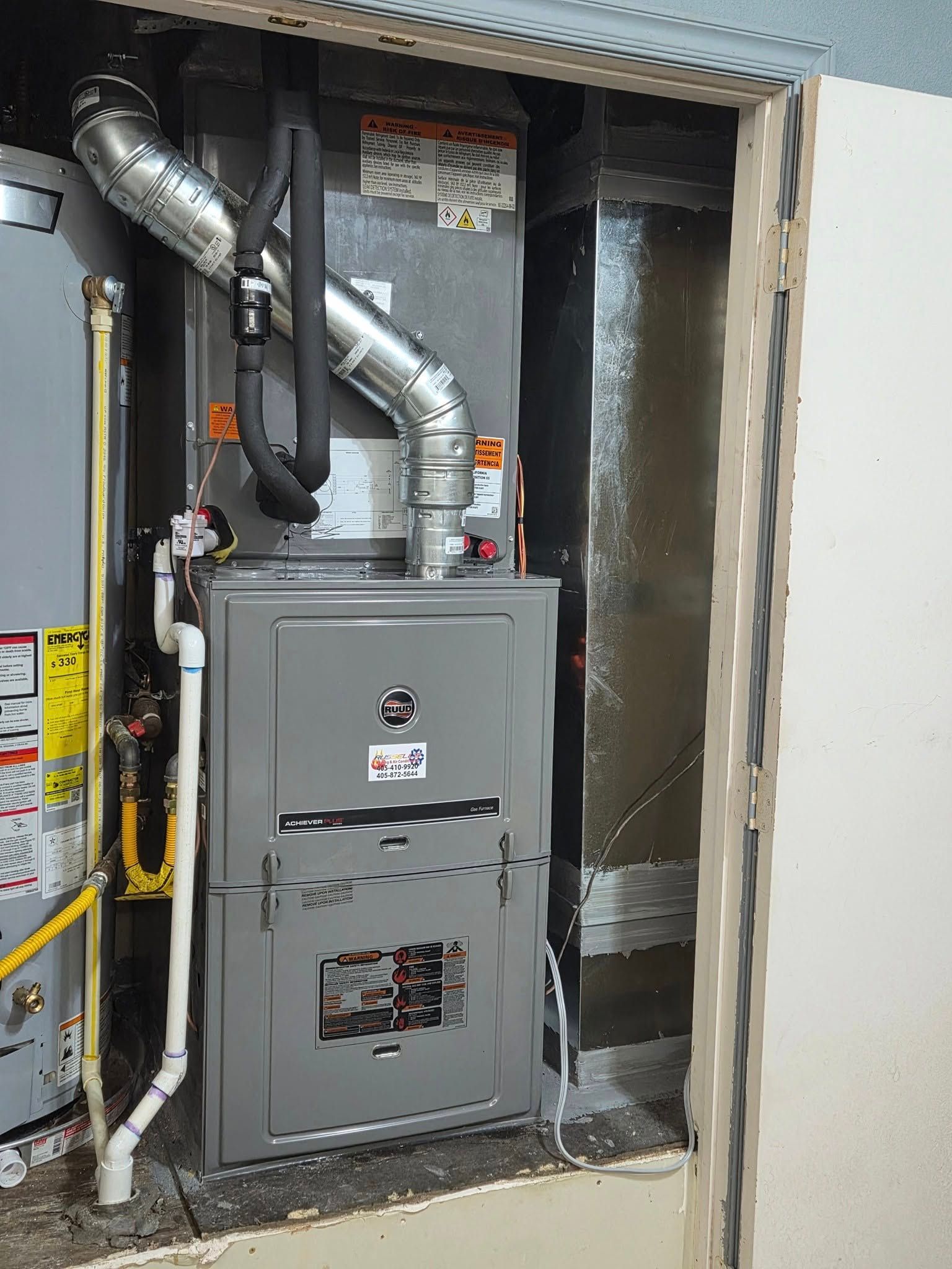 A furnace is sitting inside of a wall in a room.