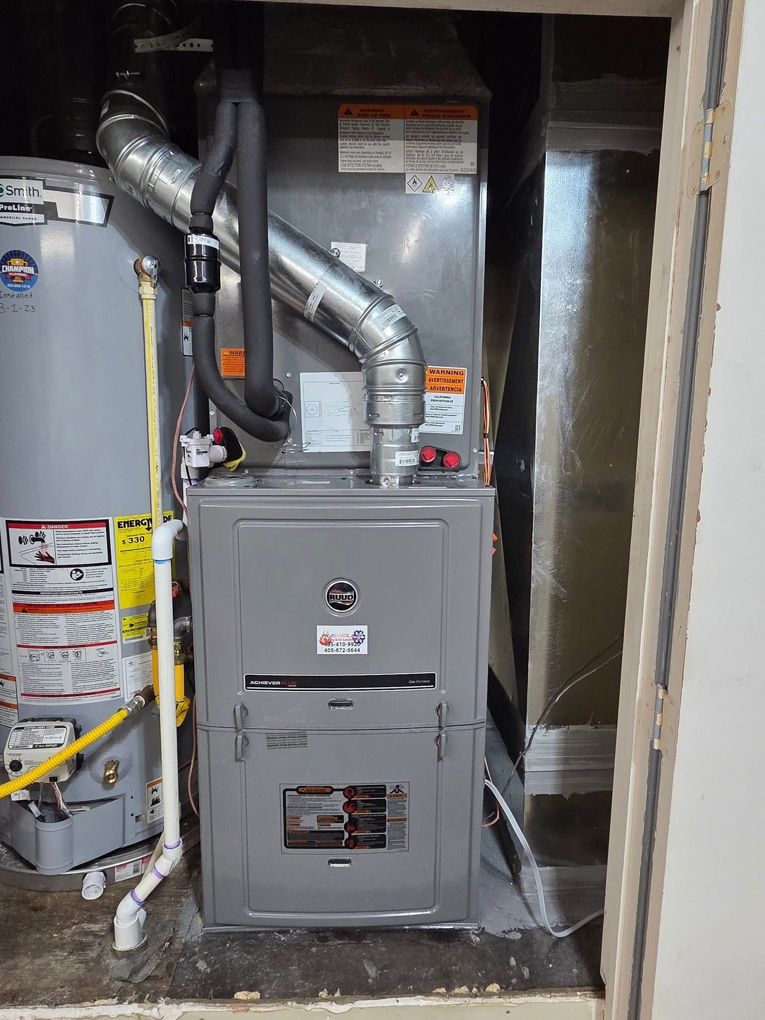 An air conditioner is sitting in a closet next to a water heater.