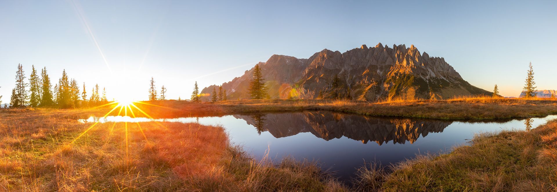 Sonnenaufgang am Hochkönigmassiv mit Spiegelung in einer Moorlacke im Salzburger Land