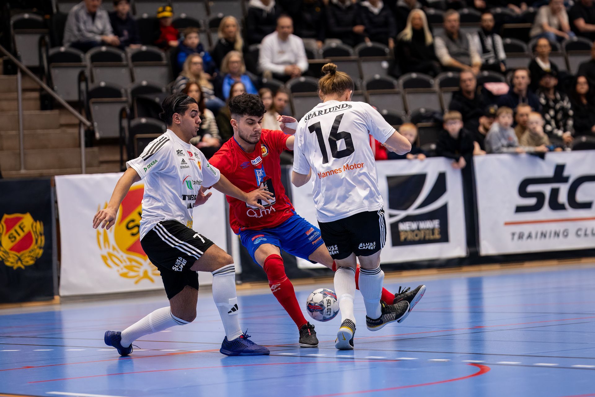 A group of soccer players are playing a game of soccer on a court.