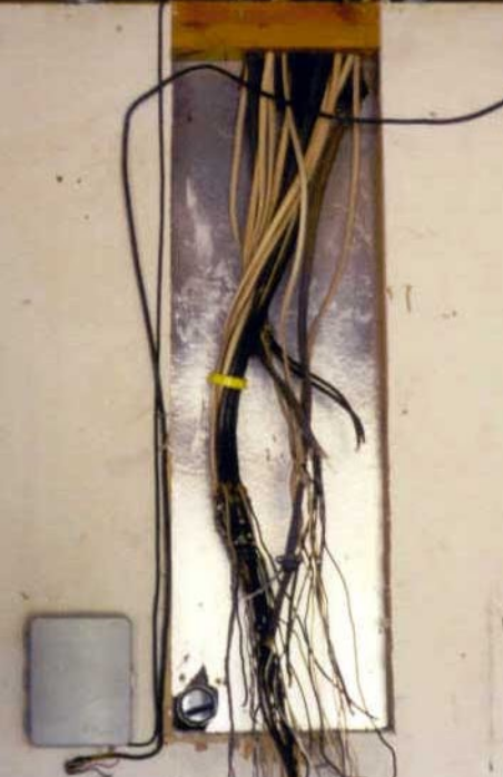 A bunch of wires are hanging from a wall
