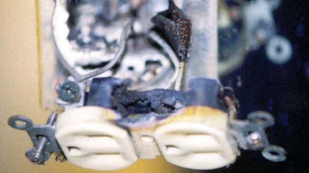 A close up of a broken electrical outlet on a wall.