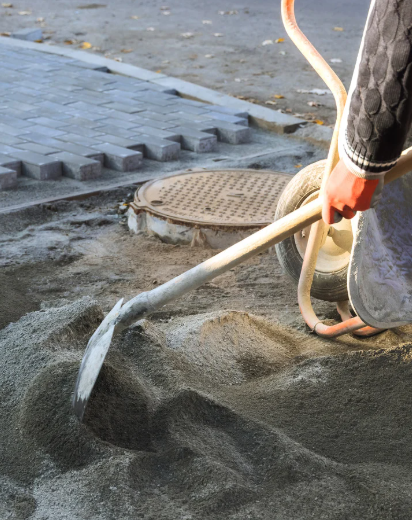 Excavator removing damaged concrete before driveway replacement project
