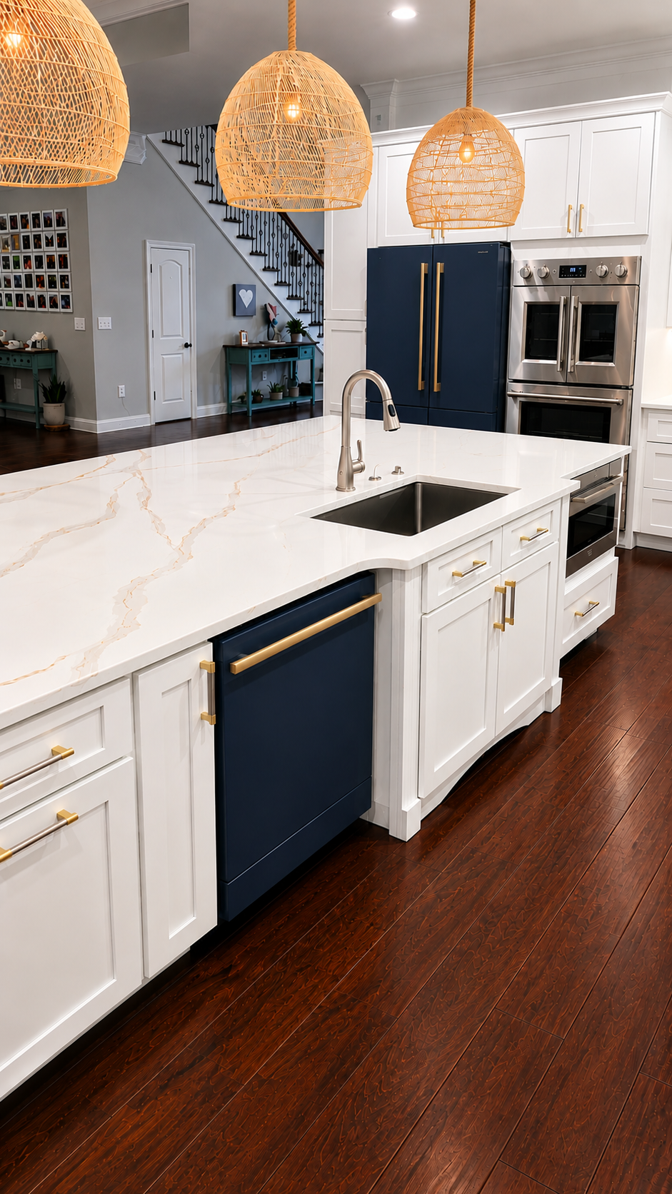 Modern kitchen with white cabinets, navy appliances, marble island, and woven pendant lights