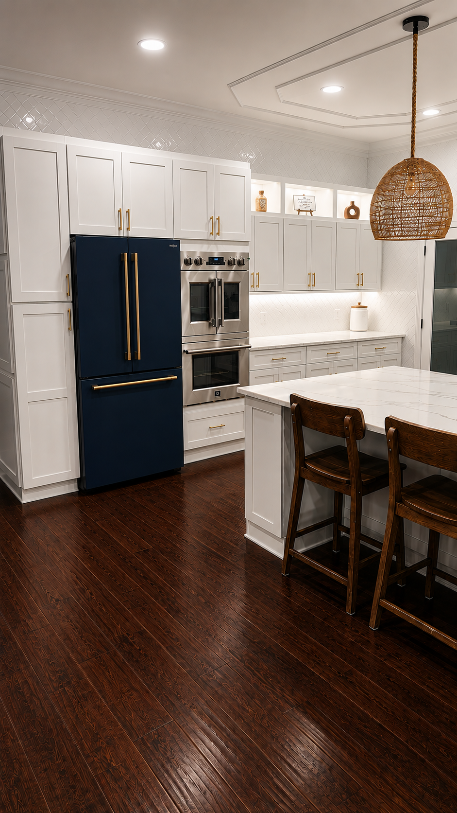 Modern white kitchen with navy fridge, wood floors, and woven pendant over a granite island