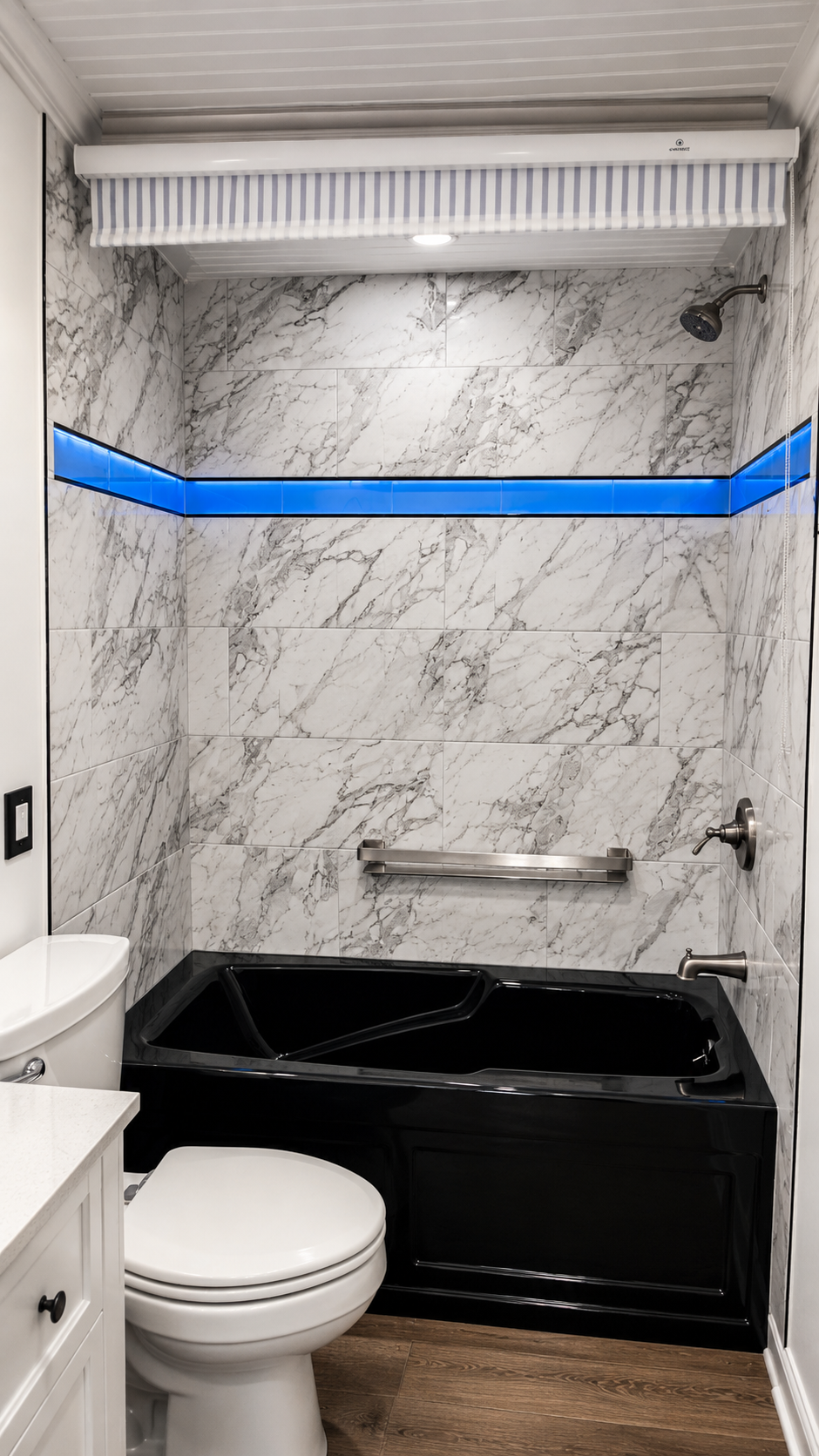 Small bathroom with marble walls, black tub, white toilet, and blue tape across the wall.