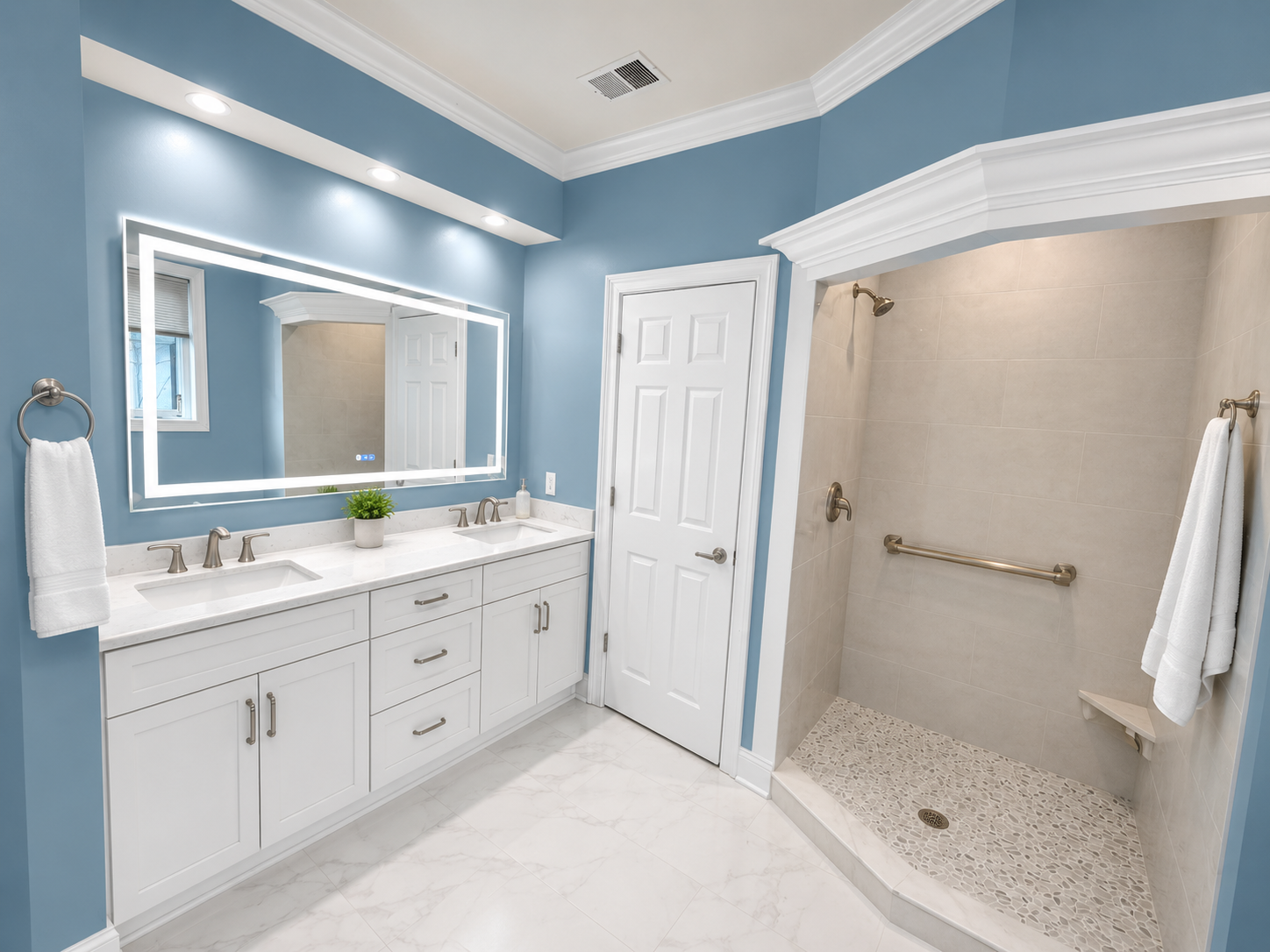 Bright blue bathroom with double vanity, large mirror, and tiled walk-in shower.