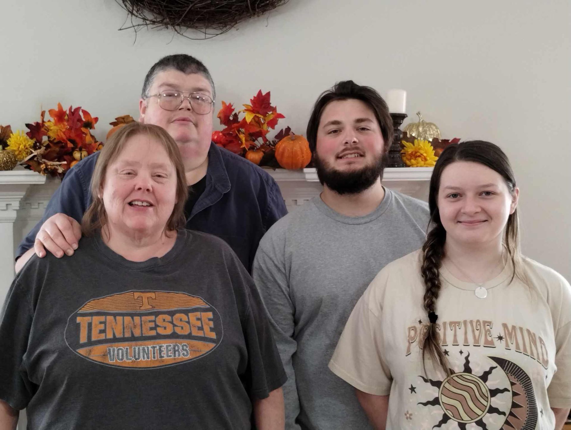 A group of people are posing for a picture in a living room.