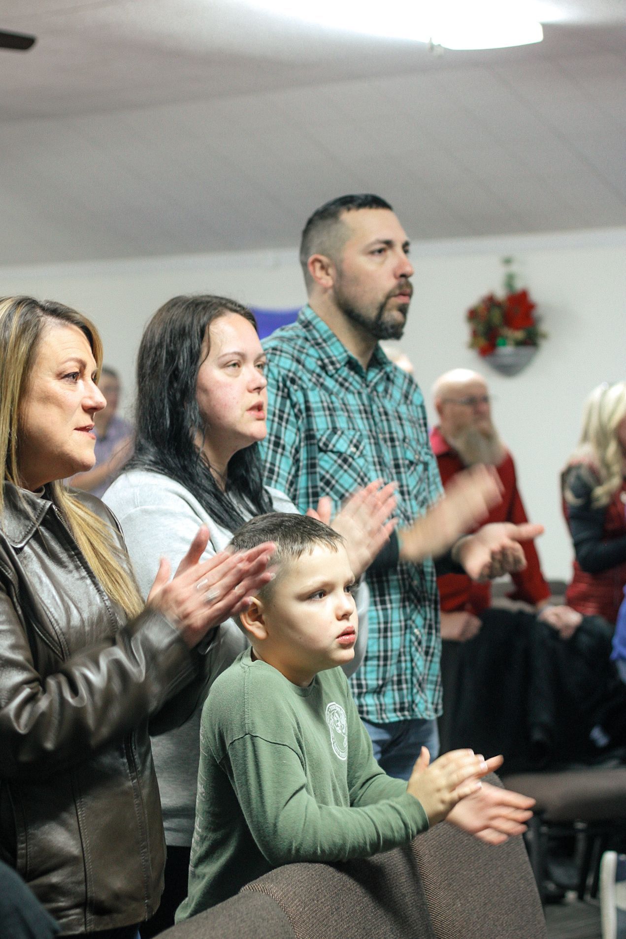 A group of people are clapping their hands in a church.