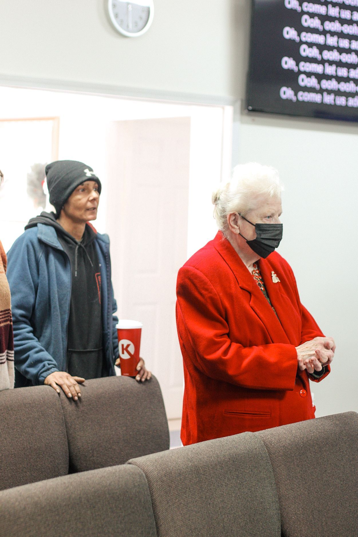 Two women wearing face masks are standing next to each other in a room.