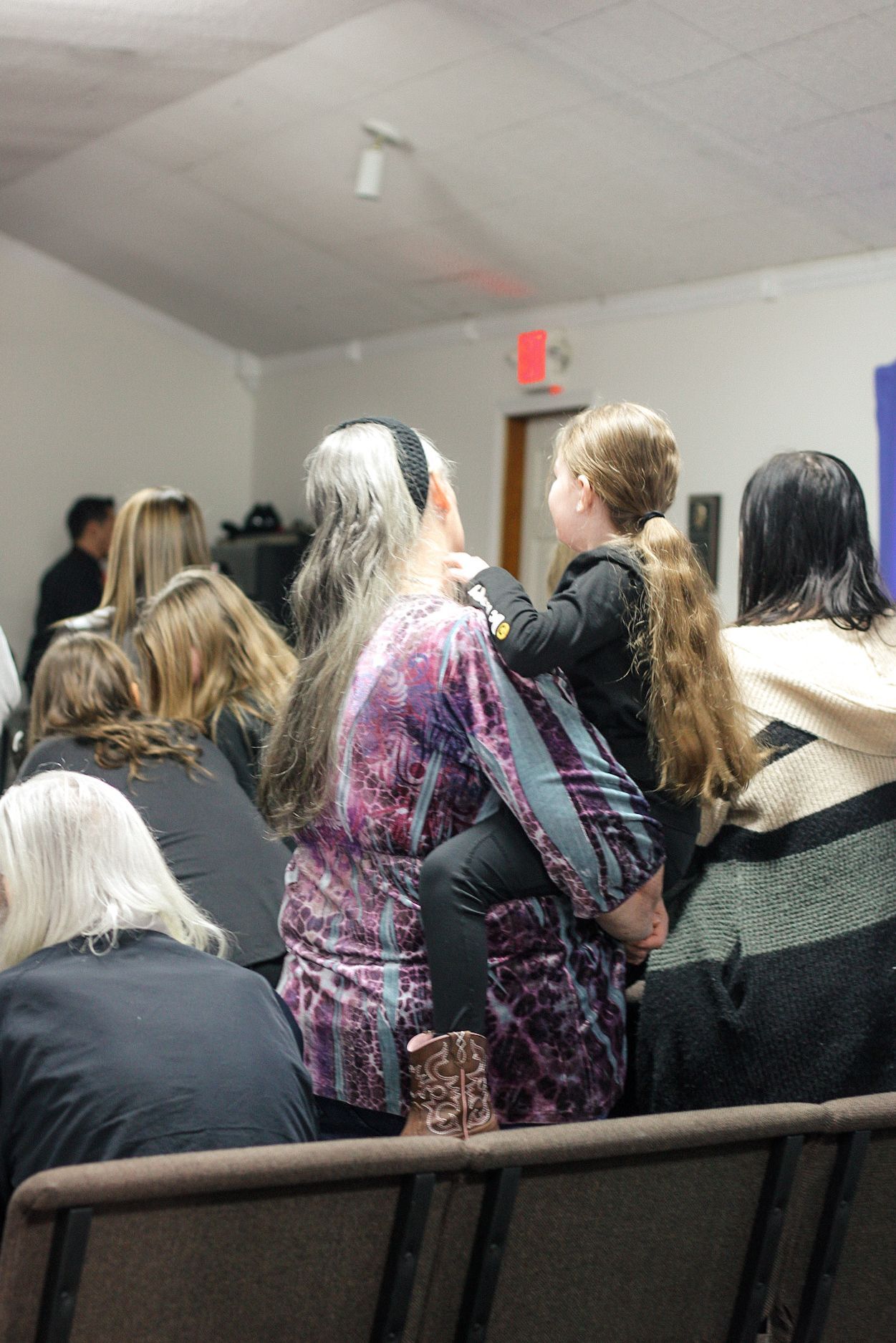 A woman is holding a child in her arms while sitting in a church.