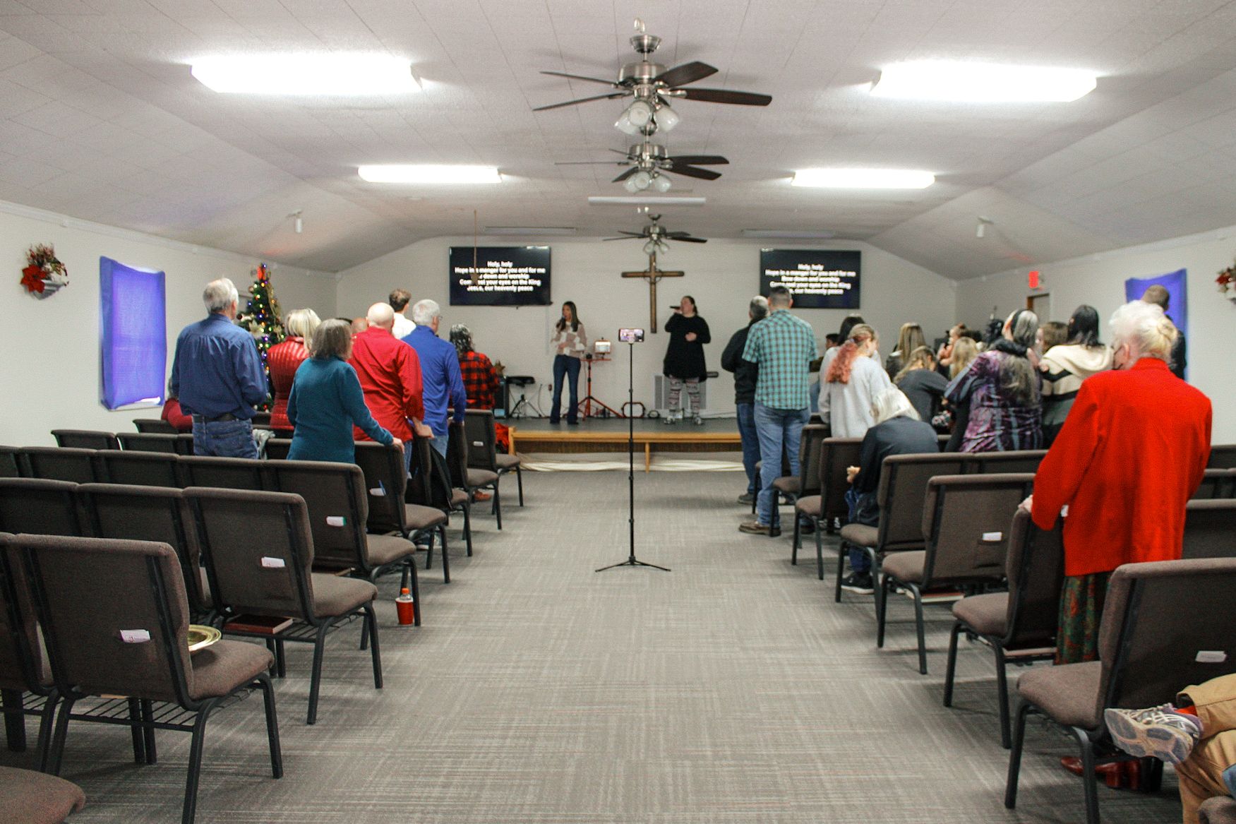 A large group of people are standing in a church.