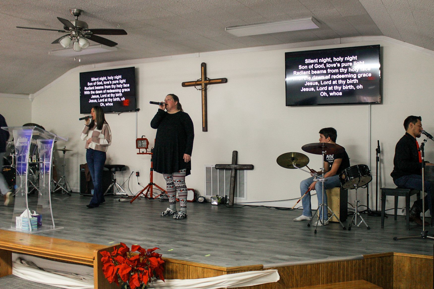 A group of people are singing and playing drums in a church.