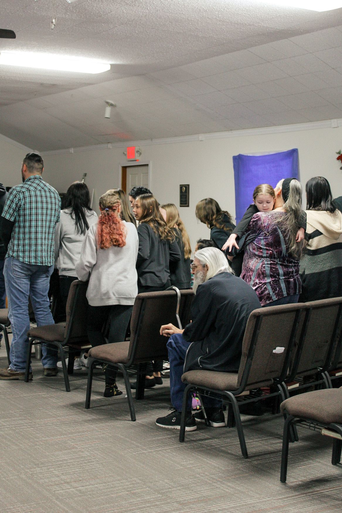 A group of people are sitting in chairs in a room.