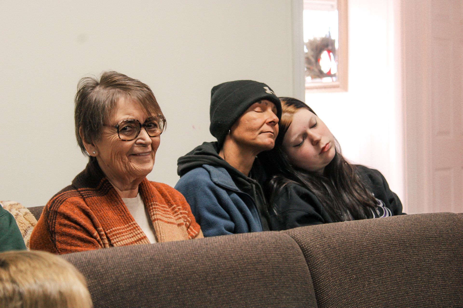 A group of people are sitting on a couch.