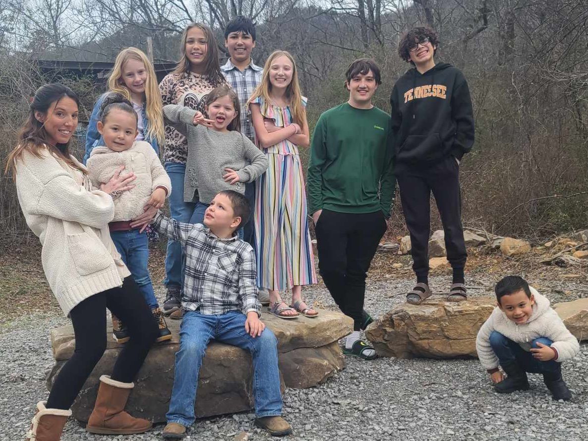A group of children are posing for a picture while sitting on rocks.