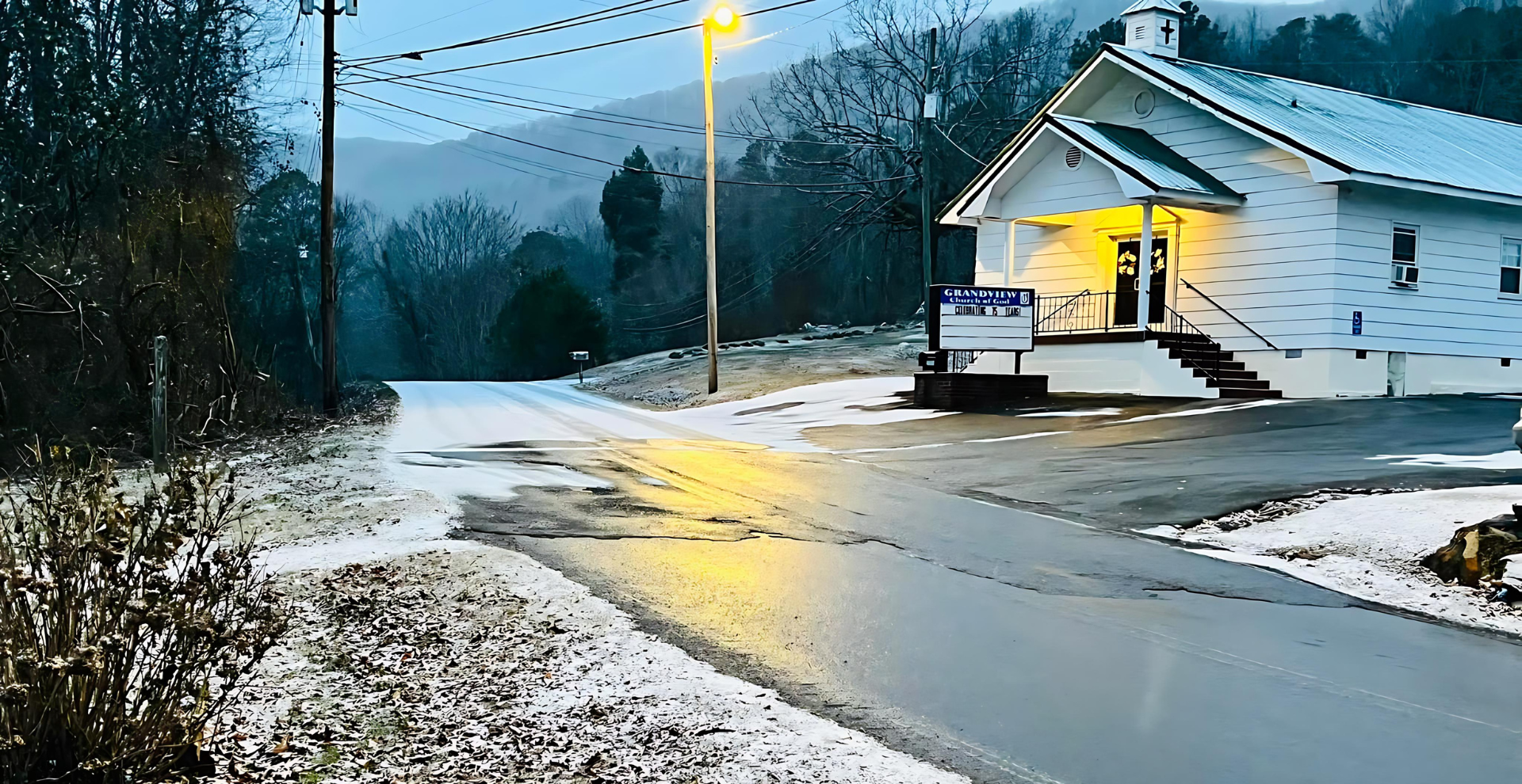 A white building is sitting on the side of a snowy road.