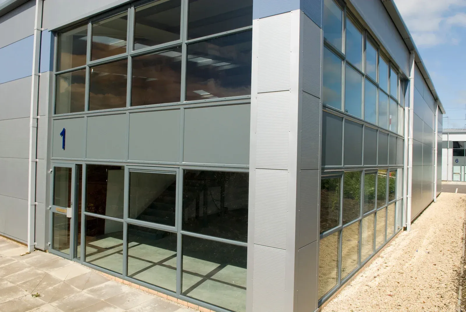 Bright office space with desks, computers, and a large window overlooking a cityscape.