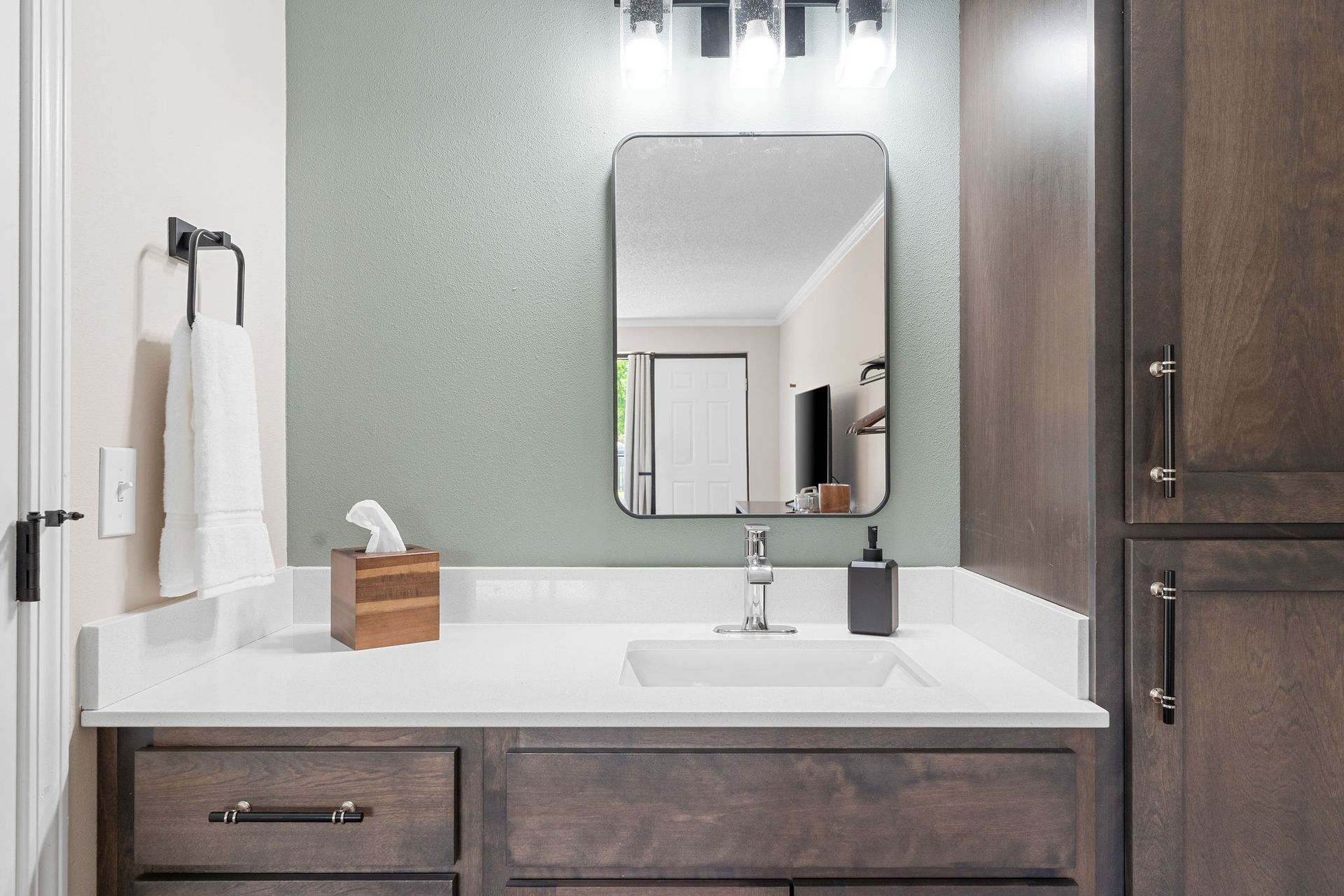 A hotel room with two beds , a couch , a table and a mirror.