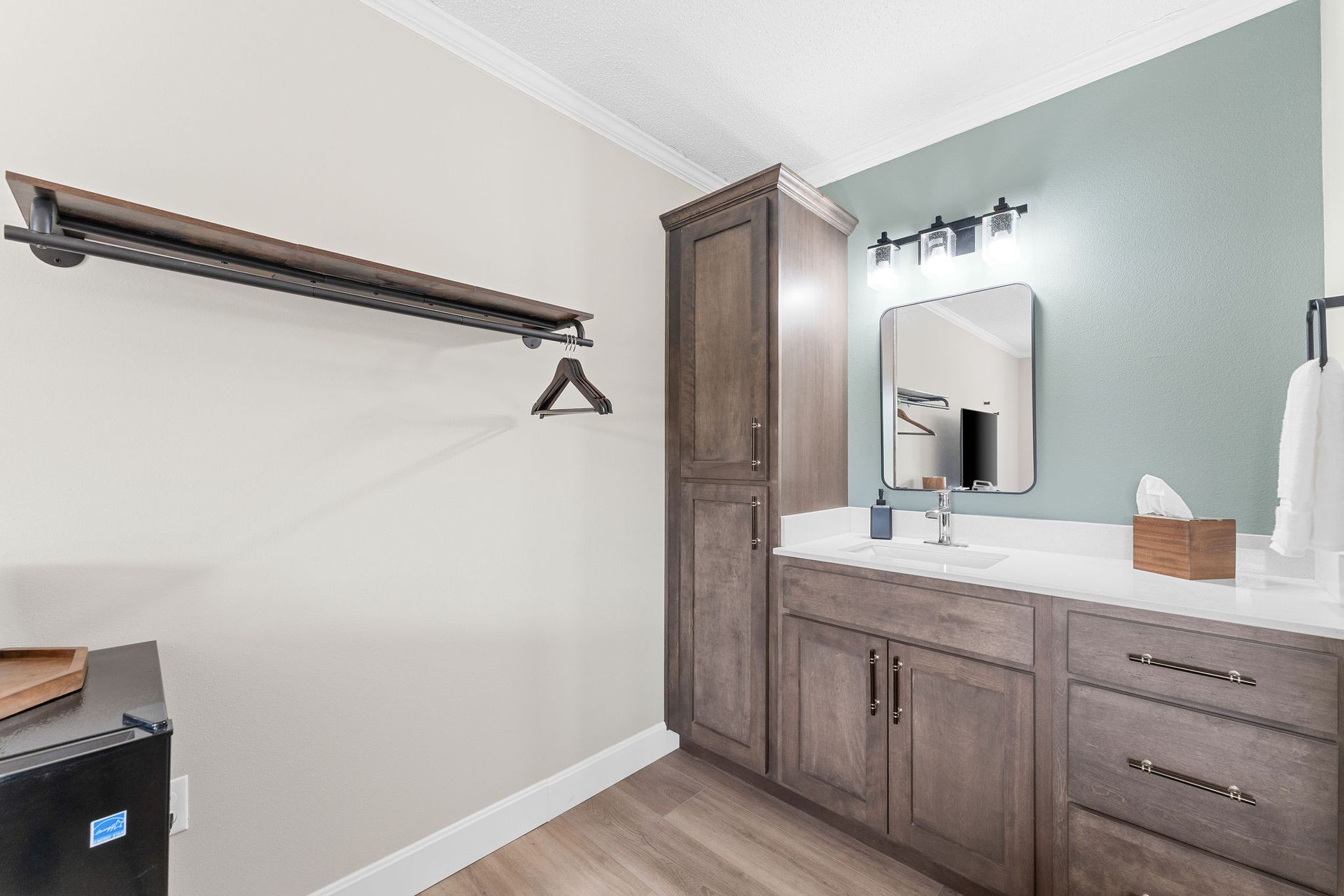 A bathroom with a sink , cabinets , and a mirror.