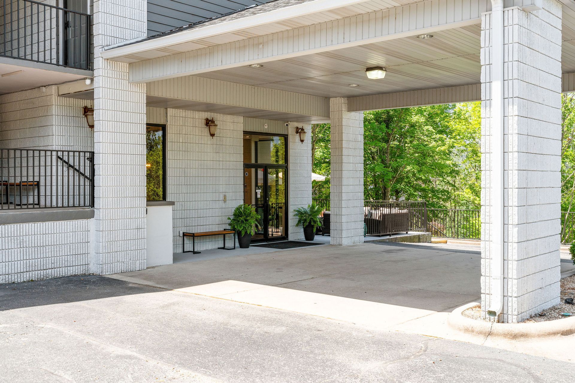 A white building with a parking lot in front of it.