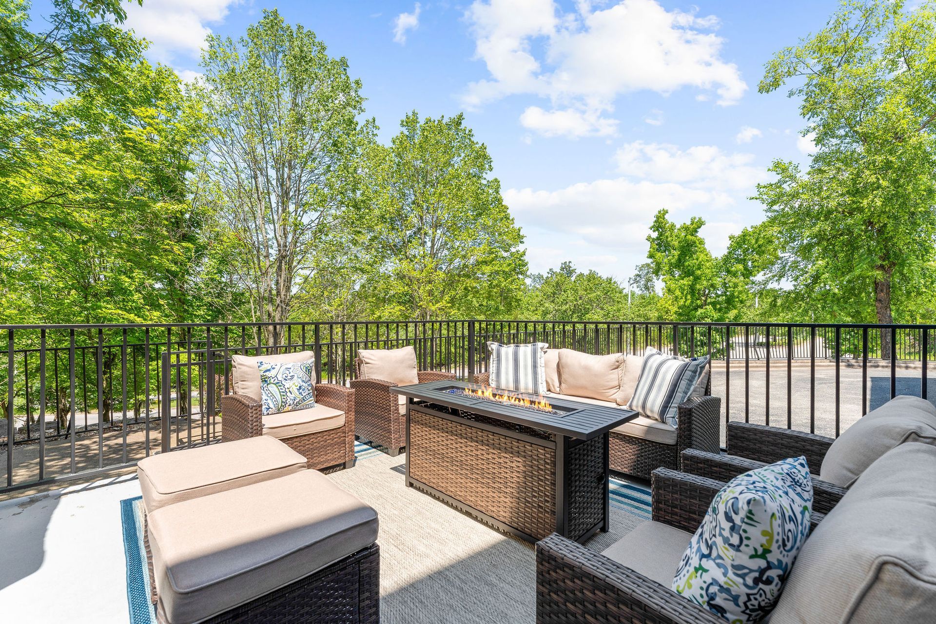 A patio with furniture and a fire pit on a sunny day.