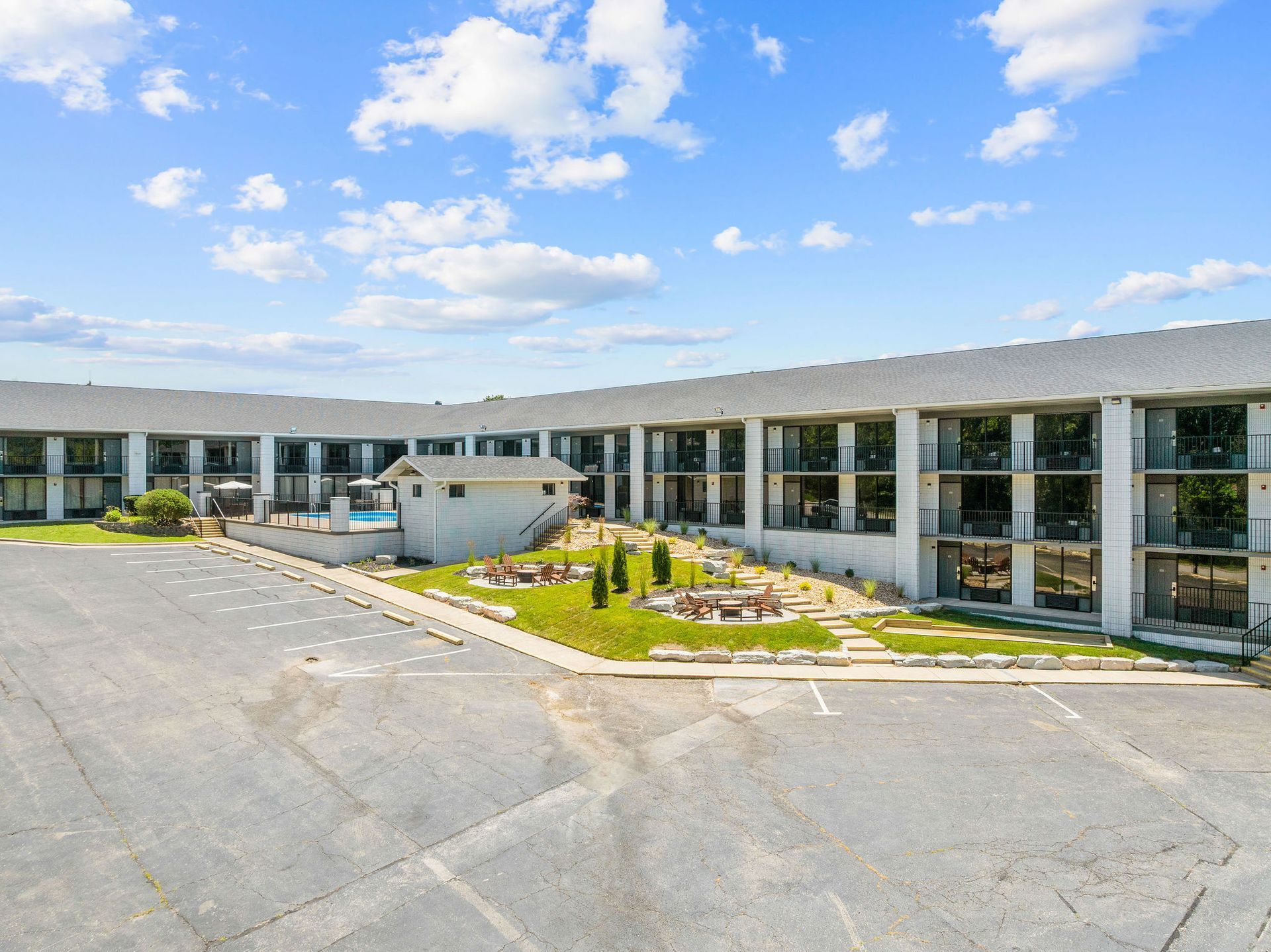 An aerial view of a hotel with a parking lot in front of it.