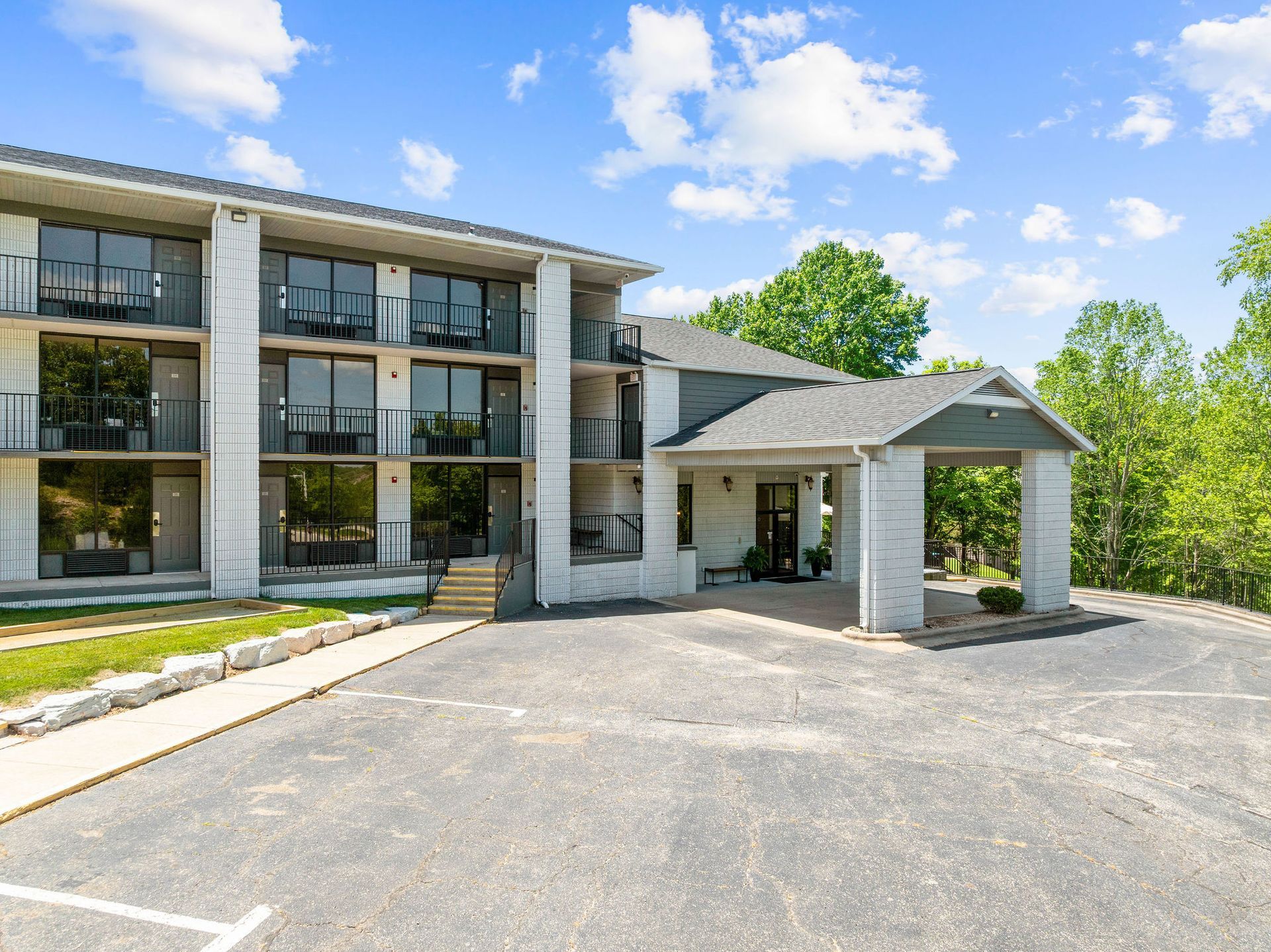 A large white building with a parking lot in front of it.