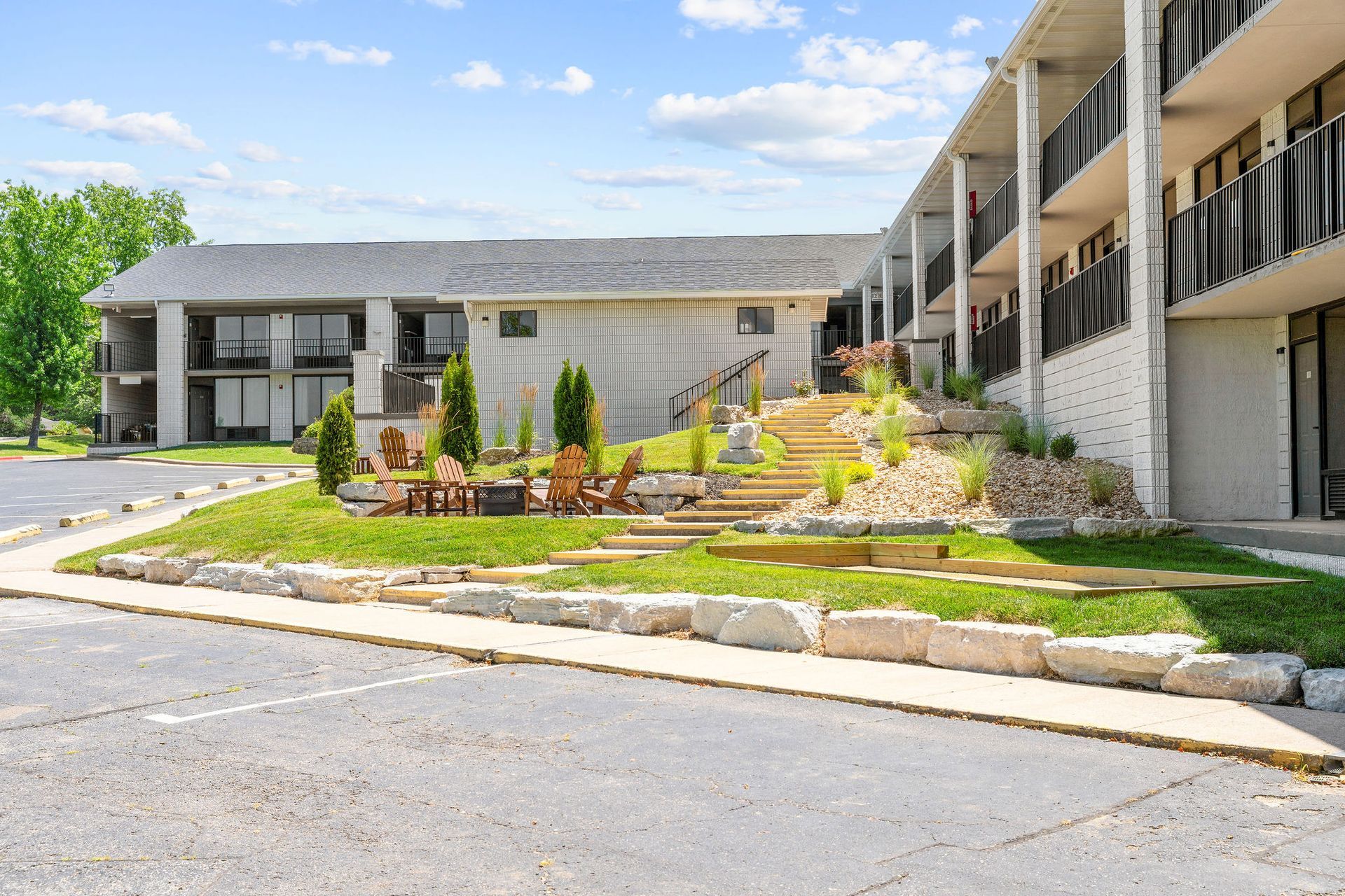 A large building with stairs leading up to it is sitting on top of a lush green hill.