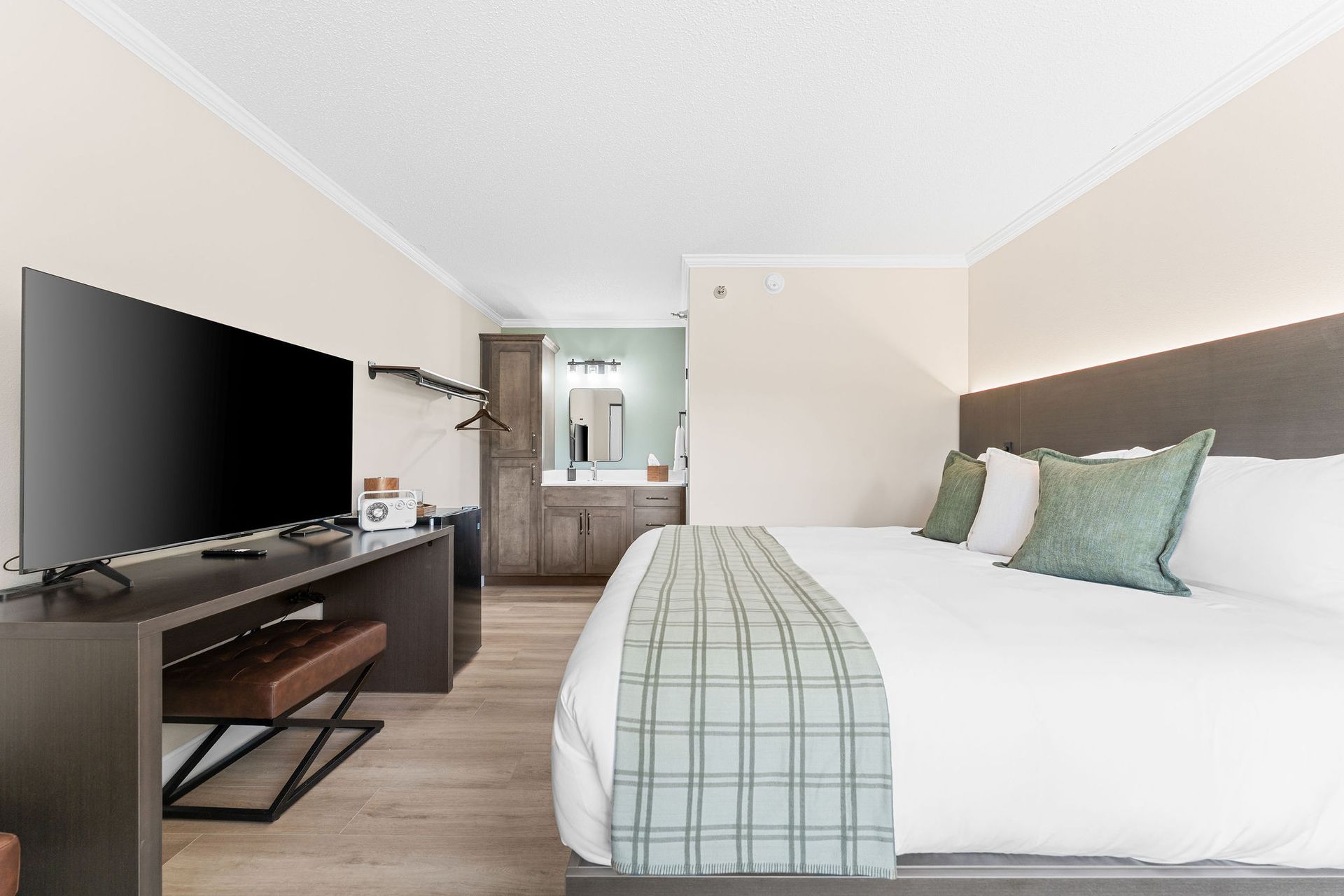 A hotel room with a king size bed and a flat screen tv.