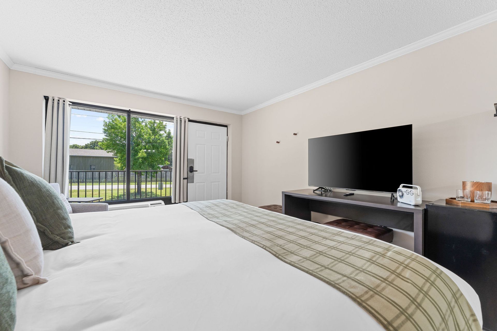 A hotel room with a king size bed and a flat screen tv.