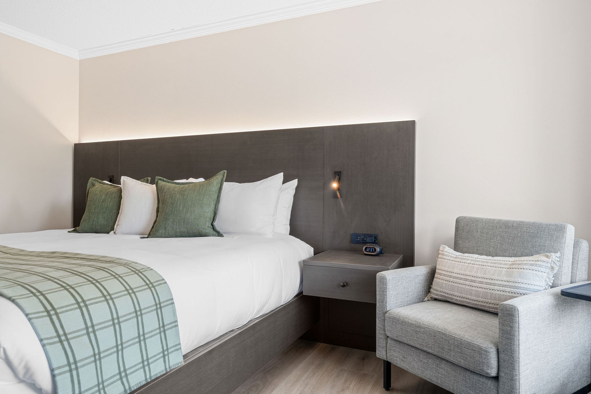 A hotel room with a king size bed and a flat screen tv.